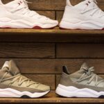 Modern sneakers showcased on wooden shelves in a stylish display setting.