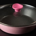 Stylish pink ceramic cooking pan with glass lid, perfect for modern kitchens.