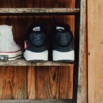 A rustic wooden shelf displaying Converse All Star and Nike shoes, perfect for fashion and vintage themes.