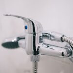 A detailed view of a sleek chrome shower faucet in a clean bathroom setting.