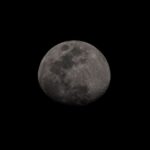 Captivating black and white photo of the moon against a dark sky, highlighting its surface details.