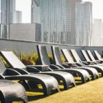 Modern rooftop with lounge chairs and skyscraper views, ideal for relaxation and urban lifestyle imagery.