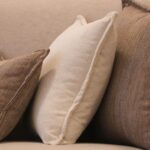 Comfortable sofa with neutral tones of brown and beige throw pillows for a warm living room setting.