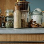 A stylish kitchen setup featuring various ingredients stored in clear glass jars on a wooden counter.