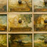 Textured background of aged cabinet with rectangular shaped drawers with colorful pictures and round handles