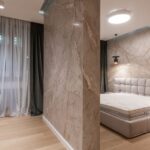 Interior of modern bright bedroom with bed and bedside tables under pendant lamps in evening
