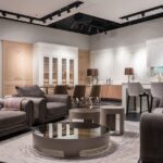 Interior of spacious furniture store with comfortable couches and armchairs and round coffee tables placed near kitchen furniture