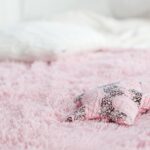 A soft pink fuzzy blanket with a decorative star-shaped pillow, creating a cozy atmosphere.