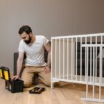A man assembling a white crib indoors with tools, focusing on DIY and home care.