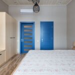 Contemporary bedroom featuring blue doors and minimalist design elements.